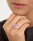 El anillo Caliche deslumbra en esta imagen, mostrando su elegante diseño en toda su majestuosidad. La gema central, en un encantador tono rosa morganita y tallada en estilo princesa, se convierte en el protagonista absoluto, irradiando un brillo delicado y romántico. Flanqueada por dos gemas en forma de corazón en los laterales, su sutileza y elegancia añaden un toque de pureza y distinción. La plata de Primera Ley 925, con un acabado en baño de rodio, realza el esplendor de cada detalle, logrando un acabad